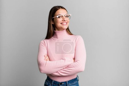 Photo for Pretty young adult woman laughing happily with arms crossed, with a relaxed, positive and satisfied pose - Royalty Free Image