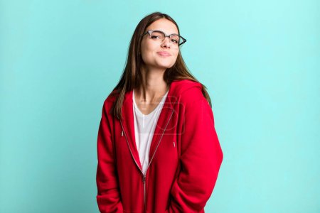 Photo for Pretty young adult woman smiling cheerfully and casually with a positive, happy, confident and relaxed expression - Royalty Free Image