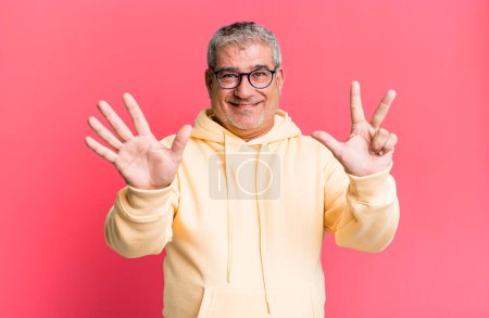 Photo for Middle age senior man smiling and looking friendly, showing number eight or eighth with hand forward, counting down - Royalty Free Image