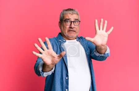 Photo for Middle age senior man feeling terrified, backing off and screaming in horror and panic, reacting to a nightmare - Royalty Free Image