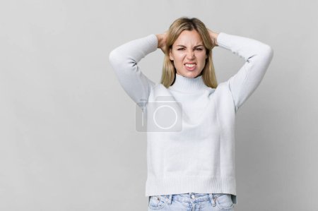 Foto de Caucasian blonde woman feeling stressed, anxious or scared, with hands on head. copy space concept - Imagen libre de derechos