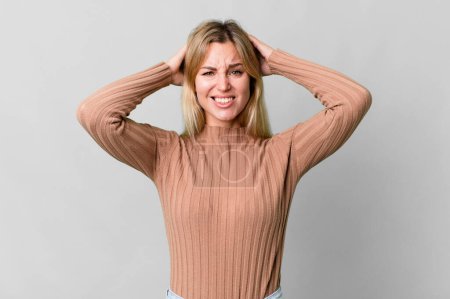 Photo for Caucasian blonde woman feeling stressed, anxious or scared, with hands on head - Royalty Free Image