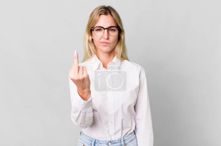 Foto de Caucasian blonde woman feeling angry, annoyed, rebellious and aggressive - Imagen libre de derechos