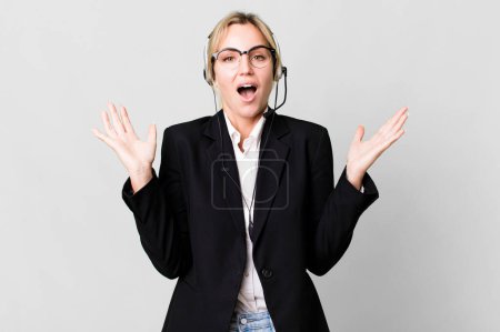 Photo for Caucasian blonde woman feeling happy and astonished at something unbelievable. telemarketing cocnept - Royalty Free Image