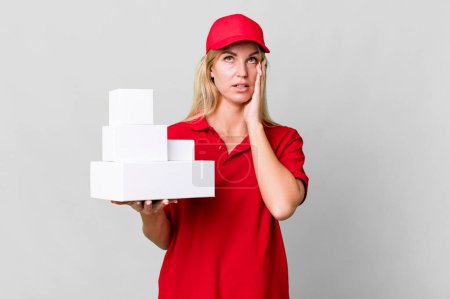 Téléchargez les photos : Caucasian blonde woman feeling bored, frustrated and sleepy after a tiresome. delivery boxes - en image libre de droit