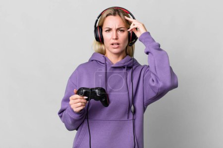 Photo for Caucasian blonde woman feeling confused and puzzled, showing you are insane. gamer concept - Royalty Free Image