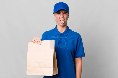 Téléchargez les photos : Caucasian blonde woman feeling disgusted and irritated and tongue out. paper bag delivery concept - en image libre de droit