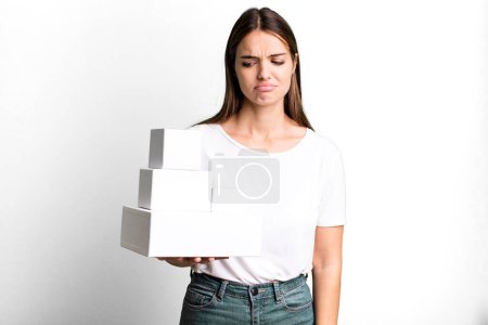 Téléchargez les photos : Young pretty woman feeling sad, upset or angry and looking to the side. blank white boxes - en image libre de droit