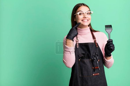 Téléchargez les photos : Young pretty woman smiling confidently pointing to own broad smile. hair dryer concept - en image libre de droit