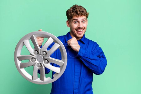 Photo for Young adult caucasian man feeling happy and facing a challenge or celebrating. car repairman or mechanic concept - Royalty Free Image