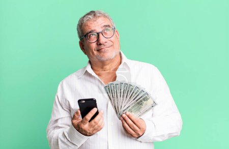 Photo for Middle age senior man with a smartphone and dollar banknotes - Royalty Free Image