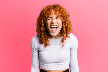 Photo for Redhair pretty woman shouting aggressively, looking very angry, frustrated, outraged or annoyed, screaming no - Royalty Free Image