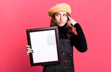 Photo for Caucasian pretty blonde woman paint art student with a beret and holding an empty frame - Royalty Free Image