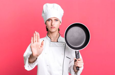 Photo for Caucasian pretty blonde woman. chef with a frying pan concept - Royalty Free Image