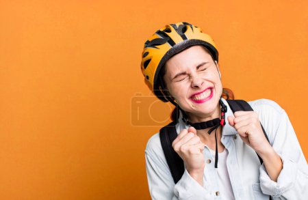 Photo for Young adult pretty delivery woman with bike helmet and bag - Royalty Free Image