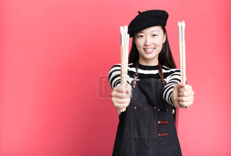 Téléchargez les photos : Young adult pretty asian woman with a beret. paint art student concept - en image libre de droit
