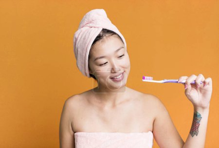 Photo for Young adult pretty asian woman with a toothbrush. - Royalty Free Image