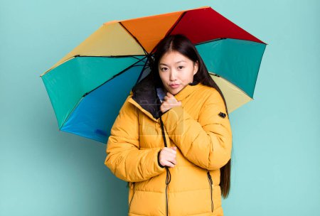 Téléchargez les photos : Jeune adulte jolie femme asiatique portant anorak et un parapluie. concept hiver et froid - en image libre de droit