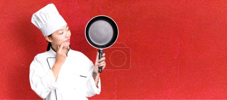 Photo for Young adult pretty asian woman. restaurant chef with a frying pan - Royalty Free Image