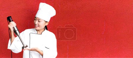 Téléchargez les photos : Jeune adulte jolie femme asiatique. chef de restaurant avec un mixeur à main - en image libre de droit