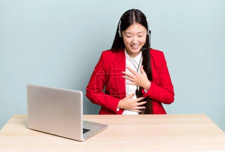Téléchargez les photos : Pretty asian woman laughing out loud at some hilarious joke. business desk concept - en image libre de droit