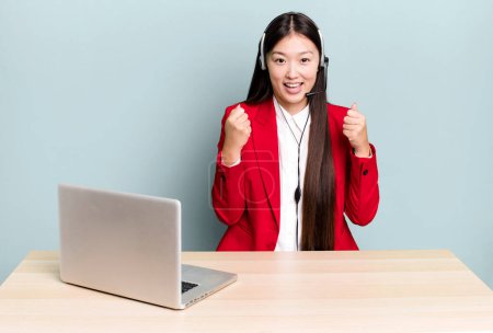 Photo for Pretty asian woman feeling shocked,laughing and celebrating success. business desk concept - Royalty Free Image
