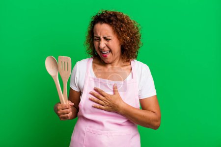 Photo for Pretty middle age woman laughing out loud at some hilarious joke. home wife chef concept - Royalty Free Image