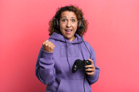 Photo for Pretty middle age woman feeling shocked,laughing and celebrating success playing virtual game. gamer concept - Royalty Free Image