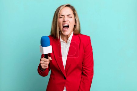 Foto de Bonita mujer rubia gritando agresivamente, luciendo muy enojada. presentador con un concepto de micrófono - Imagen libre de derechos