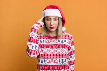 Photo for Pretty blonde woman feeling confused and puzzled, showing you are insane. christmas and santa hat concept - Royalty Free Image