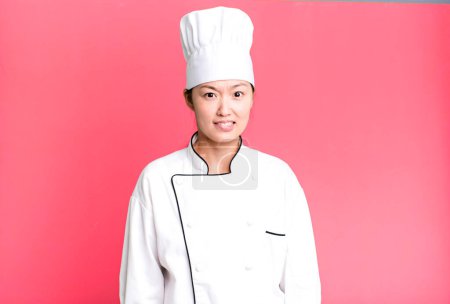 Photo for Pretty asian woman looking puzzled and confused. restaurant chef concept - Royalty Free Image