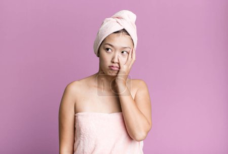 Foto de Pretty asian woman feeling bored, frustrated and sleepy after a tiresome. beauty and shower concept - Imagen libre de derechos