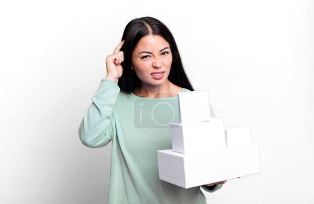 Téléchargez les photos : Hispanic pretty woman feeling confused and puzzled, showing you are insane. with white boxes packagings - en image libre de droit
