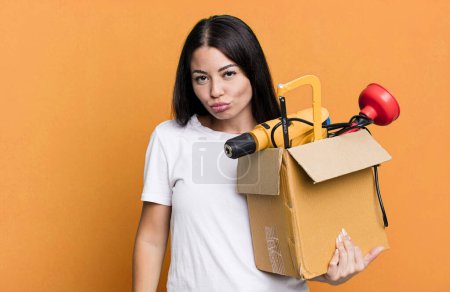 Photo for Hispanic pretty woman feeling sad and whiney with an unhappy look and crying with a tool box - Royalty Free Image