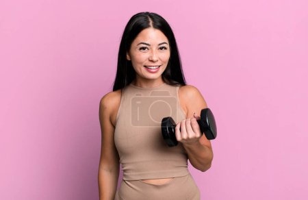 Foto de Mujer bonita hispana que parece feliz y gratamente sorprendida. concepto de fitness y mancuerna - Imagen libre de derechos