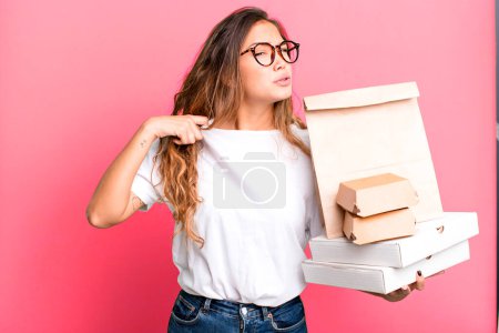 Photo for Hispanic pretty woman feeling stressed, anxious, tired and frustrated. with fast food packages - Royalty Free Image