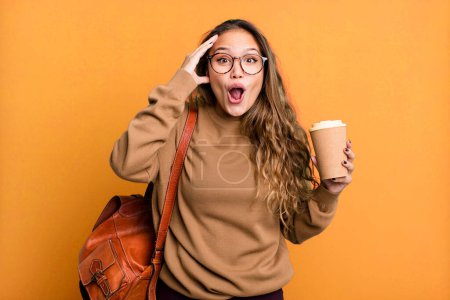 Foto de Mujer bonita hispana que parece feliz, asombrada y sorprendida. quitar el concepto de café - Imagen libre de derechos