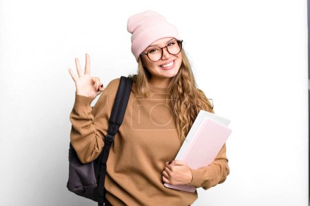 Photo for Hispanic pretty woman feeling happy, showing approval with okay gesture. university student concept - Royalty Free Image
