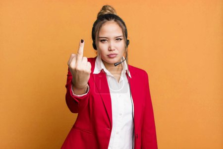 Foto de Hispanic pretty woman feeling angry, annoyed, rebellious and aggressive. telemarketing concept - Imagen libre de derechos