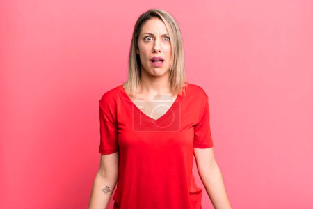 Photo for Blonde adult woman feeling terrified and shocked, with mouth wide open in surprise - Royalty Free Image