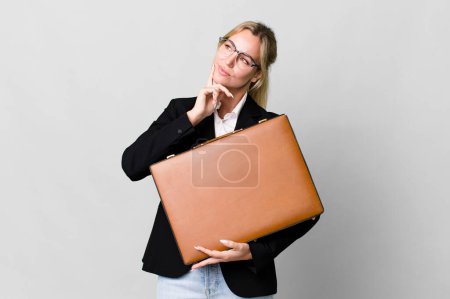 Téléchargez les photos : Pretty caucasian businesswoman with a leather suit case - en image libre de droit