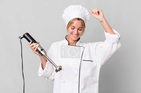 Photo for Pretty caucasian restaurant chef woman with a hand blender - Royalty Free Image