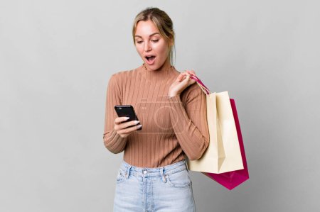 Téléchargez les photos : Pretty caucasian woman with shopping bags and a smartphone - en image libre de droit