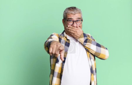 Photo for Middle age senior man laughing at you, pointing to camera and making fun of or mocking you - Royalty Free Image
