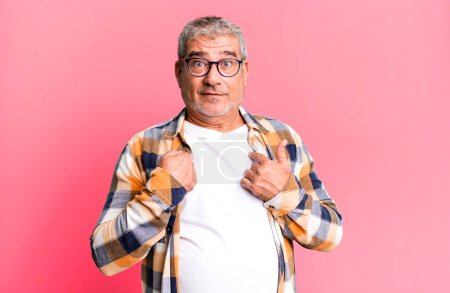 Téléchargez les photos : Homme âgé d'âge moyen se sentant heureux, surpris et fier, pointant vers soi avec un regard excité et étonné - en image libre de droit