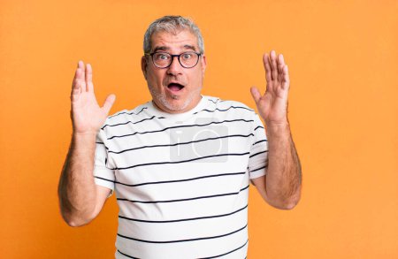 Photo for Middle age senior man looking shocked and astonished, with jaw dropped in surprise when realizing something unbelievable - Royalty Free Image