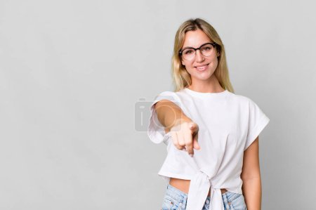 Téléchargez les photos : Caucasian blonde woman pointing at camera choosing you. copy space concept - en image libre de droit