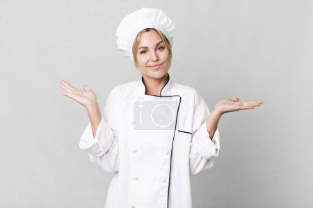 Foto de Caucasian blonde woman feeling puzzled and confused and doubting. chef concept - Imagen libre de derechos