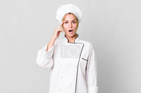 Téléchargez les photos : Caucasian blonde woman looking surprised, realizing a new thought, idea or concept. chef concept - en image libre de droit