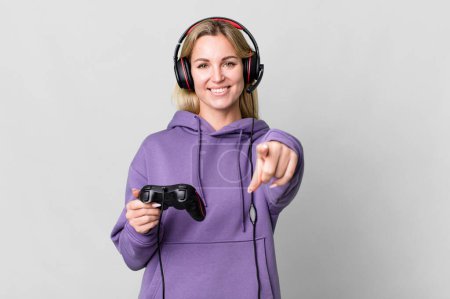 Photo for Caucasian blonde woman pointing at camera choosing you. gamer concept - Royalty Free Image